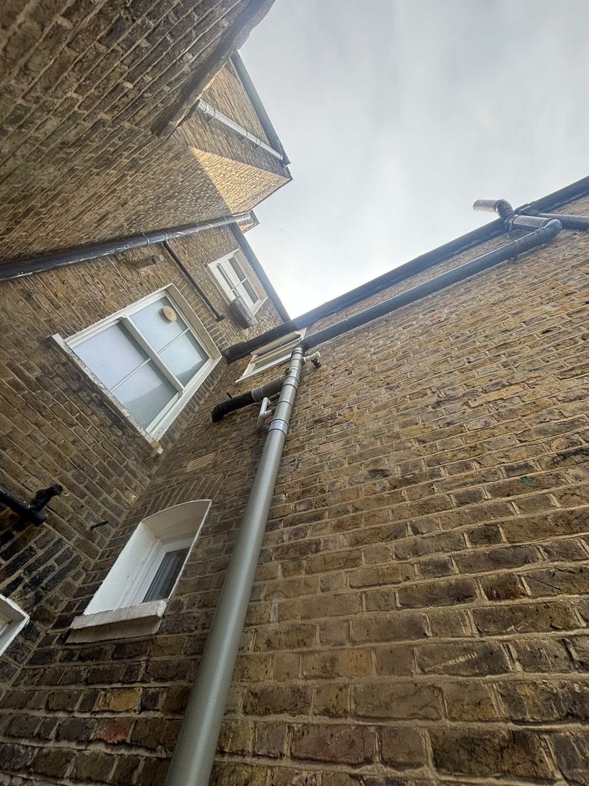 Looking up at new pipe on side of home